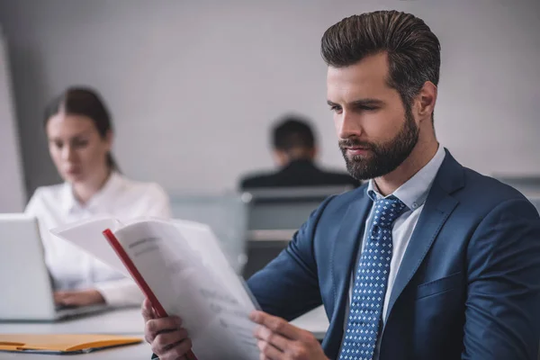 Barbudo hombre con documento mujer detrás de la computadora portátil — Foto de Stock