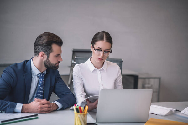 Бородатый мужчина и темноволосая женщина проверяют что-то на ноутбуке