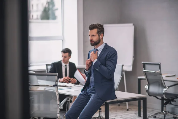 Mannen i kostym rätar ut sin slips på kontoret — Stockfoto