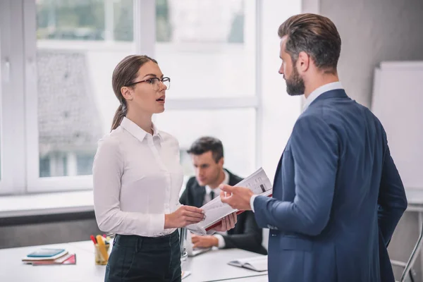 Mujer con gafas y hombre barbudo de pie hablando — Foto de Stock