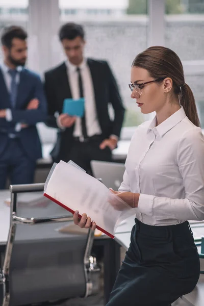 Attentive woman in profile looking at documents