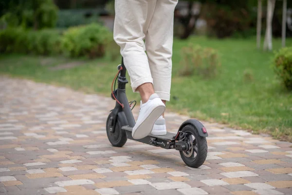 Close up picture of a person riding a scooter in the park — Stock Photo, Image
