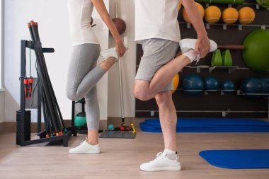 Beyaz spor ayakkabılı bir adam ve bir kadın bacaklarını açıyorlar.