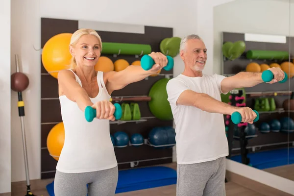 Un hombre y una mujer haciendo ejercicio con pesas y sintiéndose positivos — Foto de Stock