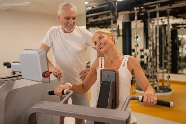 Pareja madura haciendo ejercicio juntos en el gimnasio y sintiéndose muy bien — Foto de Stock