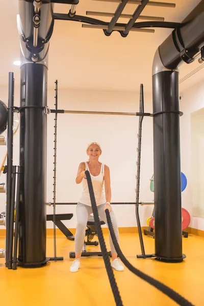 Blonde Frau in Sportbekleidung beim Training mit Seilen — Stockfoto
