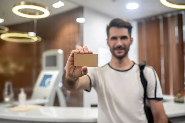 수염을 깎고 있는 수컷이 카메라 앞에 클럽 카드를 보여 주고 있다 — 스톡 사진