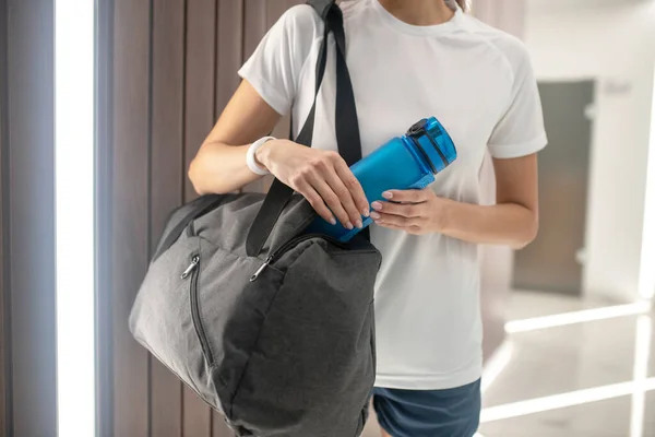 Detailní záběr ženských rukou drží tašku a láhev s vodou — Stock fotografie