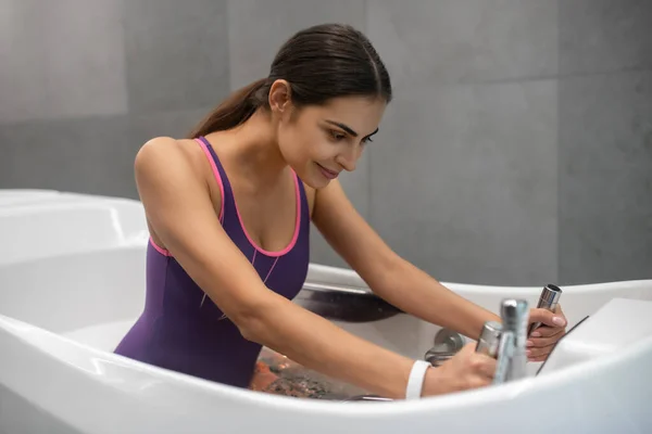 Темноволосая женщина сидит в гидромассажной ванне, получает гидротерапию — стоковое фото