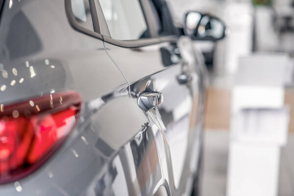 Rear view of new grey car in showroom