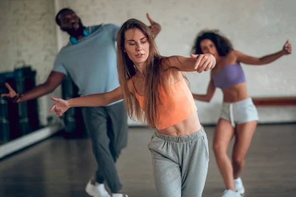 Mujer aprendiendo coreografía hip-hop con sus compañeros de grupo —  Fotos de Stock