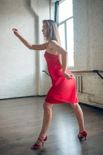 Mulher vestindo um vestido vermelho dançando uma dança rítmica — Fotografia de Stock