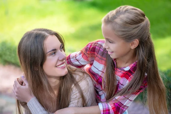 Sonriente hija abrazando a su madre feliz fuera —  Fotos de Stock