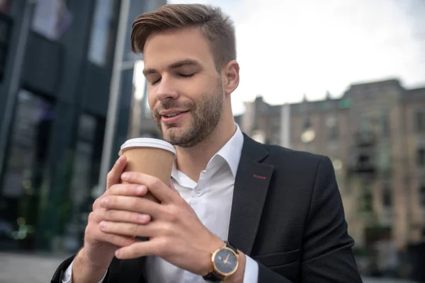 Elegante hombre de negocios oliendo café y buscando relajado —  Fotos de Stock