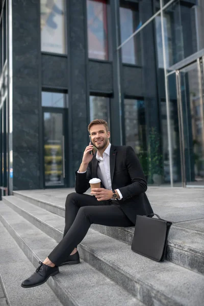 Κομψός άνδρας επιχειρηματίας κάθεται στα σκαλιά και μιλάει στο τηλέφωνο — Φωτογραφία Αρχείου