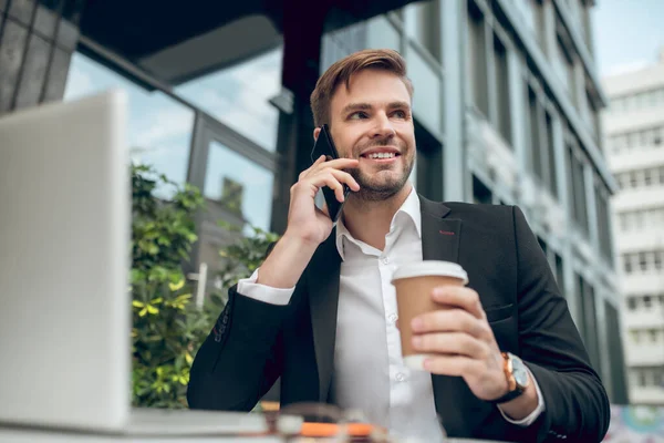 Schöner junger Geschäftsmann beim Kaffee und beim Telefonieren — Stockfoto