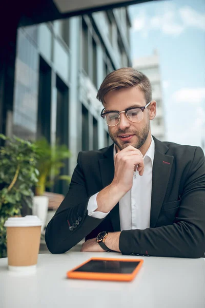 Joven hombre de negocios guapo con gafas que parecen reflexivas — Foto de Stock