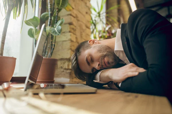 Jeune homme d'affaires dans une veste noire sieste dans un café fatigué après le travail — Photo