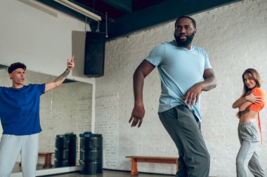 Üç profesyonel dansçı birlikte prova yapıyor.