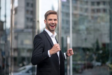 Genç yakışıklı iş adamı heyecanlı ve mutlu görünüyor.