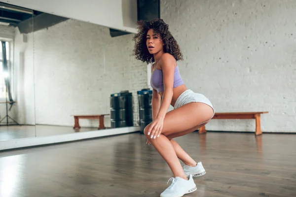 Woman making sitting up movements while dancing — Stock Photo, Image