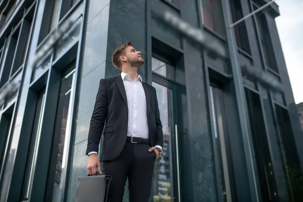 Νεαρός επιχειρηματίας κοιτάζει ψηλά στέκεται κοντά στο επιχειρηματικό κέντρο — Φωτογραφία Αρχείου