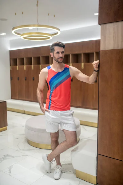 Young man in bright tshirt standing in the changing room — Stock Photo, Image