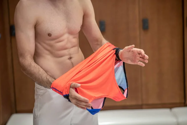 Close up picture of sporty man changing his clothes — Stock Photo, Image