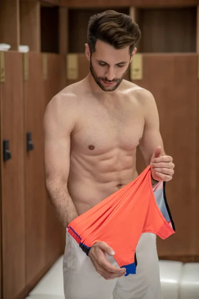 Sporty man changing his clothes after workout — Stock Photo, Image