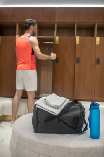 Sportieve man in de buurt van het kluisje in een kleedkamer — Stockfoto