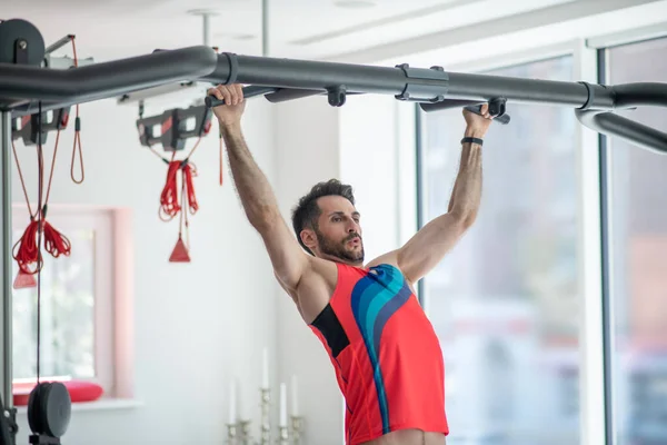 Jonge donkerharige man met een training in de sportschool en op zoek naar geconcentreerde — Stockfoto