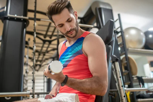 Joven moreno trabajando en sus brazos con mancuernas — Foto de Stock