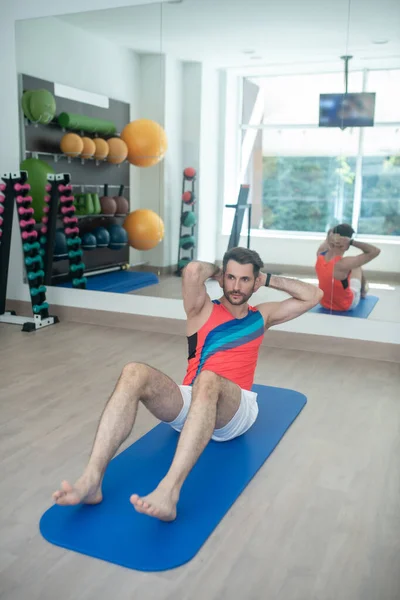 Barbudo joven macho haciendo abdominales en el gimnasio — Foto de Stock