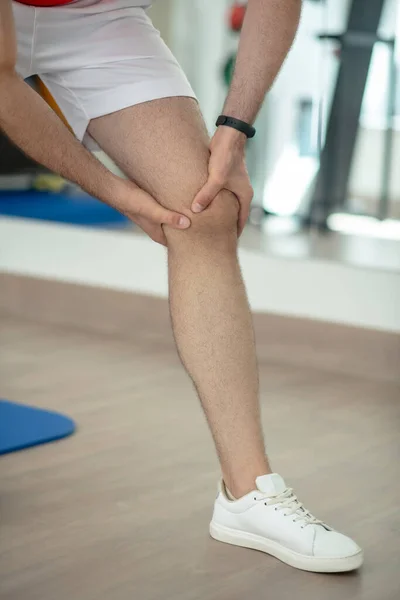 Detailní záběr mužských rukou masírujících bolestivé koleno — Stock fotografie