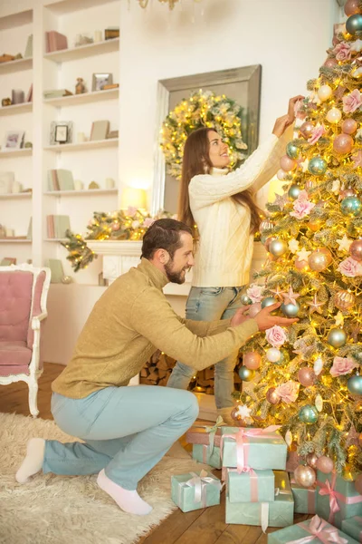 Mladý šťastný pár zdobení vánoční stromeček spolu — Stock fotografie