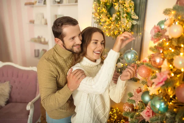 Jovem casal feliz sstanding perto da árvore de Natal e olhando feliz — Fotografia de Stock