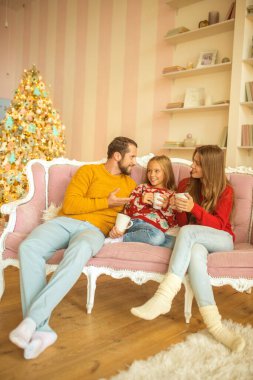 Sevimli bir aile kanepede oturuyor ve kendini rahat hissediyor.