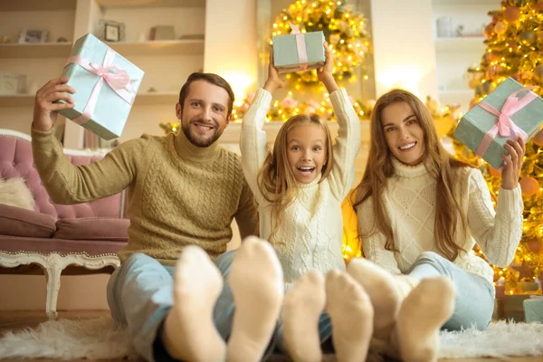 Leuke familie zit op de vloer en voelt zich feestelijk — Stockfoto