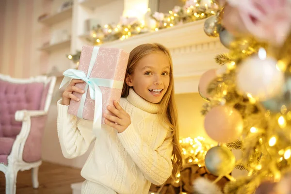 Hosszú hajú aranyos lány kezében egy karácsonyi ajándék — Stock Fotó