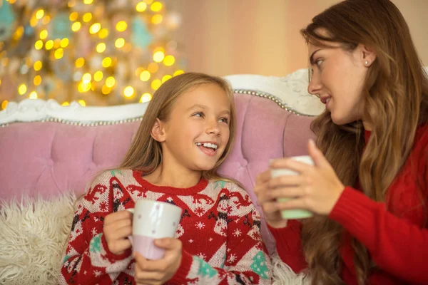 Mom and daughter sitting on the sofa and talking — Stock Photo, Image