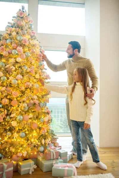 Vader en dochter versieren kerstboom en kijken betrokken — Stockfoto