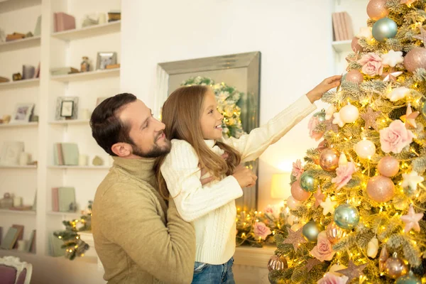 Junger Mann und seine Tochter schmücken Weihnachtsbaum — Stockfoto