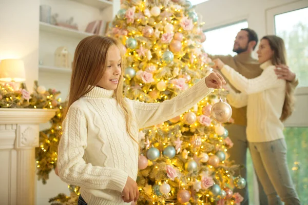 Jolie famille heureuse décorant arbre de Noël et se sentant bien — Photo