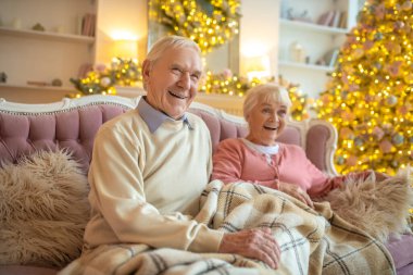 Yaşlı çift güzel bir odada oturuyor ve kendilerini rahat hissediyorlar.