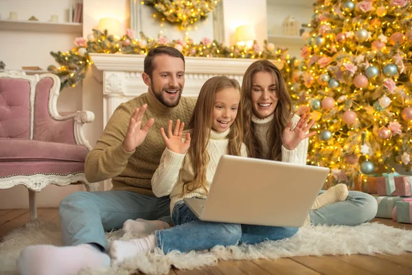 Les jeunes parents et leur fille ayant un appel vidéo — Photo