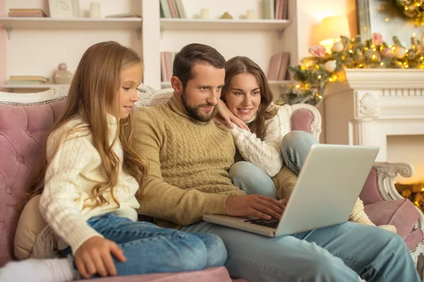 Jong familie zitten kijken opgewonden terwijl het hebben van een video gesprek — Stockfoto