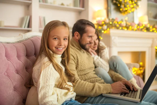 Jonge familie kijkt iets op een laptop — Stockfoto