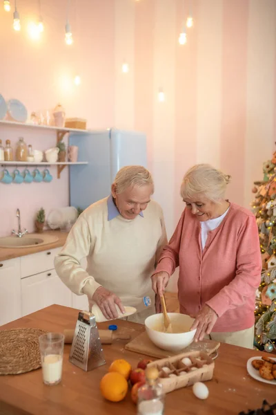 Couple âgé cuisiner quelque chose dans la cuisine et regarder impliqué — Photo