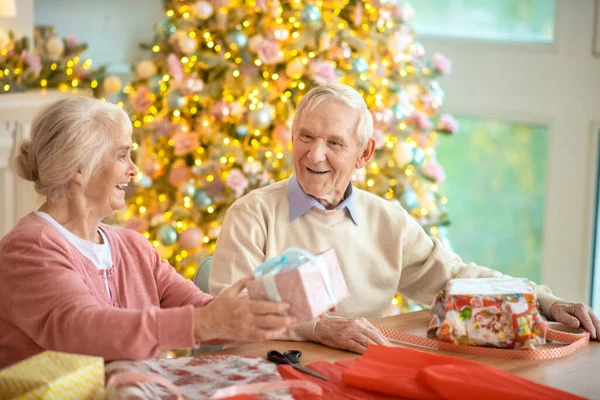 Starsza para przygotowuje prezenty świąteczne i czuje się dobrze — Zdjęcie stockowe