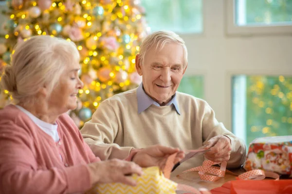 Starsza para przygotowuje prezenty świąteczne i czuje się dobrze — Zdjęcie stockowe